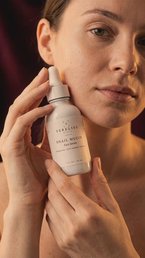 Serelise Snail Mucin Face Serum — held in warm light